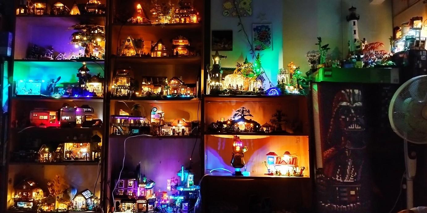 Lit shelves of small brick villages glowing in teal, orange and purple, with a Darth Vader figure on the right